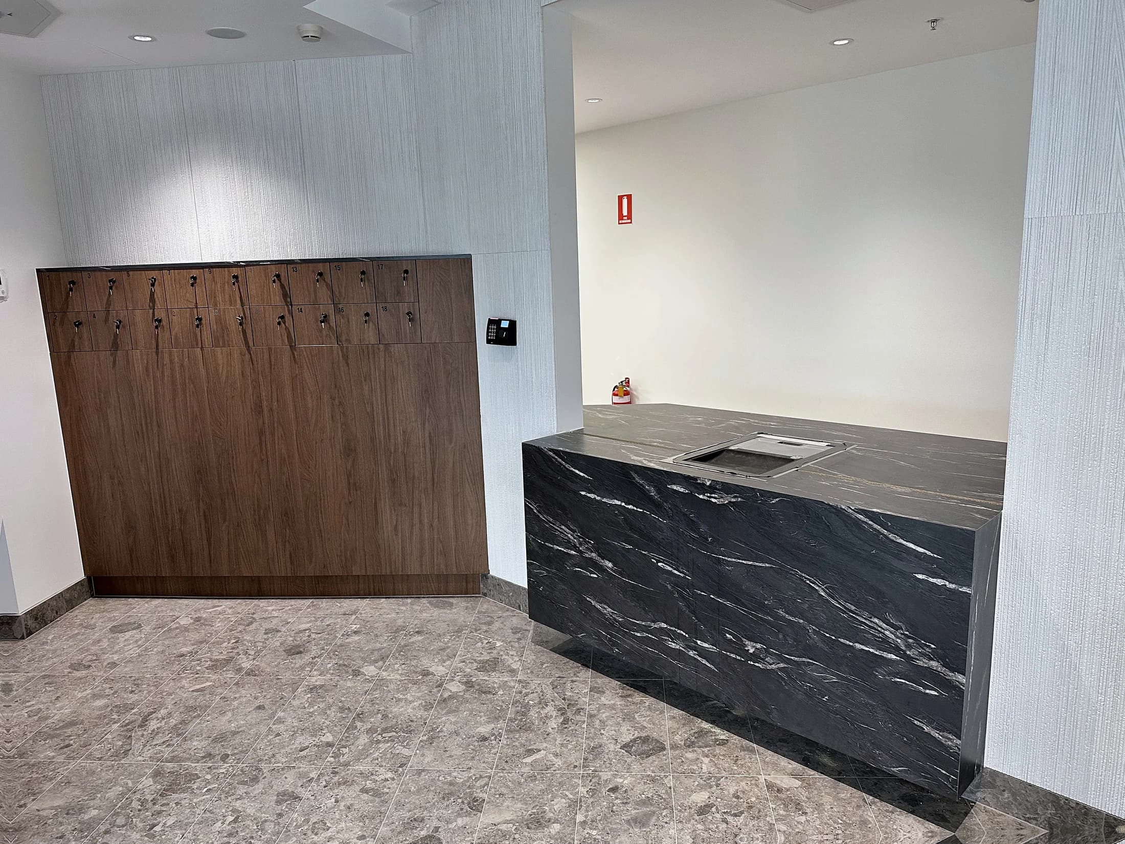 Stone reception counter with timber wall and storage joinery